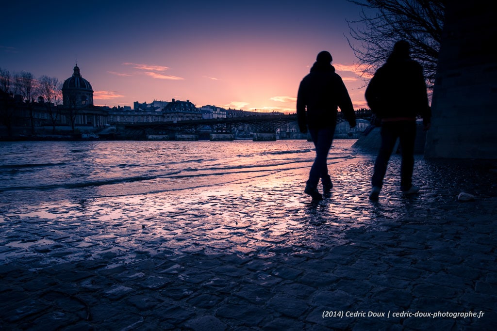 Silhouettes sur les pavés des Quais de Seine à Paris le soir