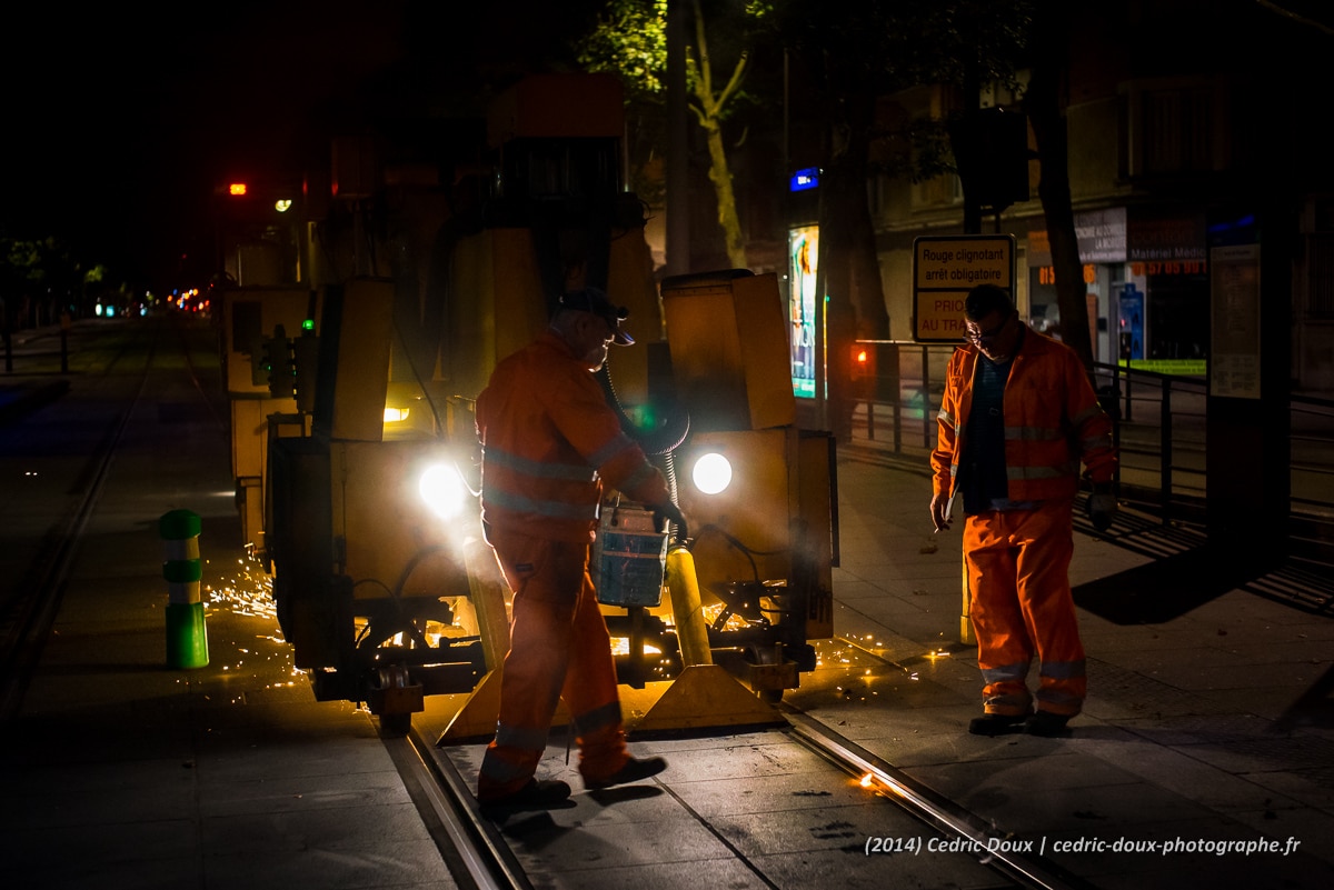 Paris la nuit, les ouvriers et la meuleuse entretiennent les rails du tramway
