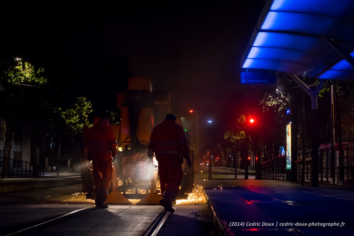 Les ouvriers et la meuleuse sur les voies du tramway parisien la nuit