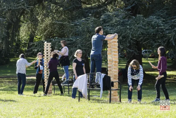 Image de l'entreprise, raconter votre histoire 4 Équipe de collaborateurs construisant une tour géante en bois lors d’un team building d’entreprise en extérieur